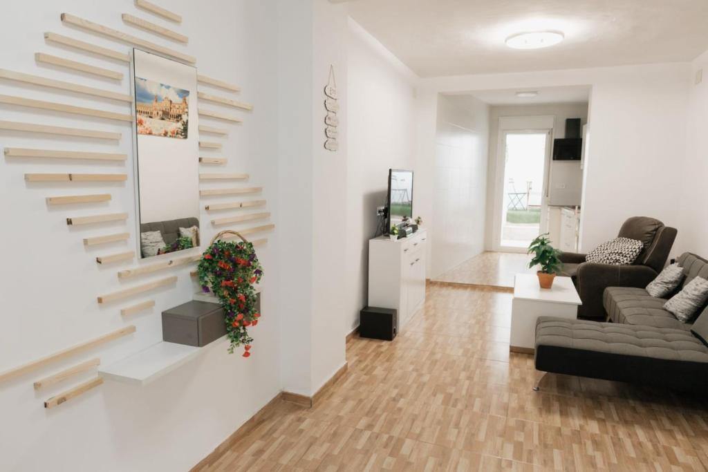 a living room with white walls and a staircase at Casa Las niñas in La Algaba