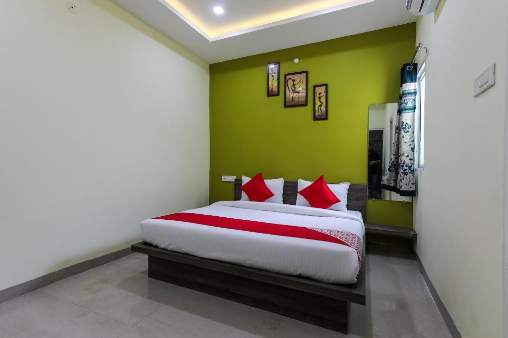 - une chambre avec un lit dans un mur vert dans l'établissement Hotel O Nabhyansh Elite Lokmanya Nagar railway station, à Indore