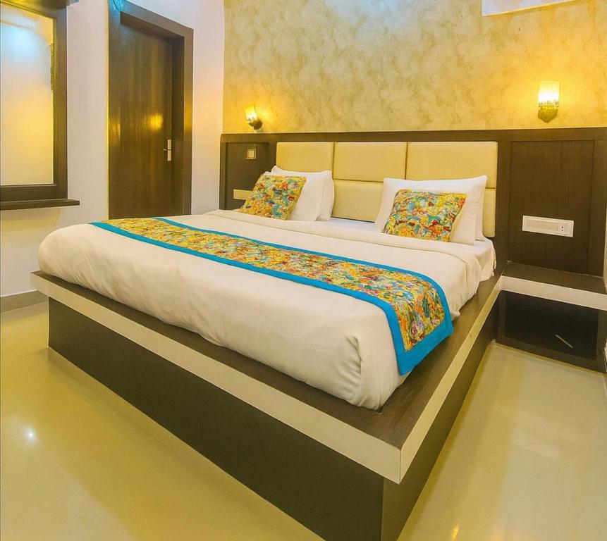 a bedroom with a large bed in a room at Hotel New Vintage Mathura in Mathura