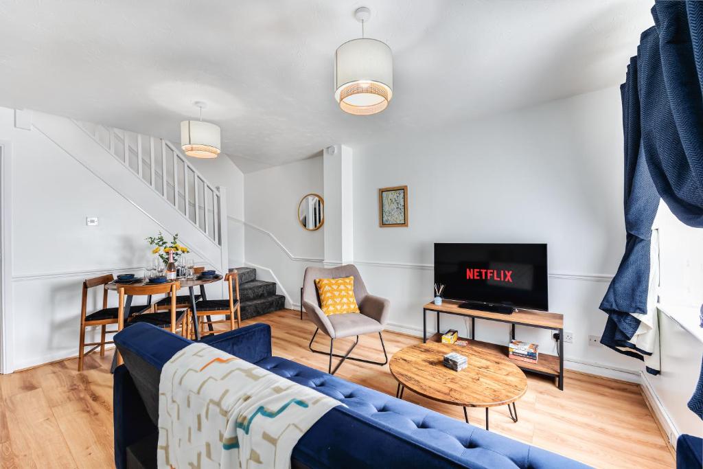 a living room with a blue couch and a table at Cosy Sleeps 5 Bedford Stay Superfast WiFi in Bedford