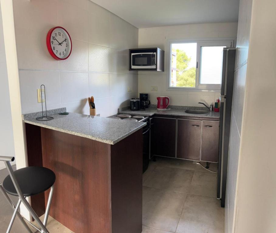 a small kitchen with a counter and a clock on the wall at Latitud 28 in Mar Azul