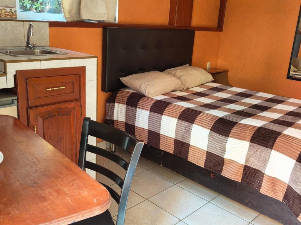 a small bedroom with a bed and a sink at Hostal casa de los delfines in Puerto Villamil