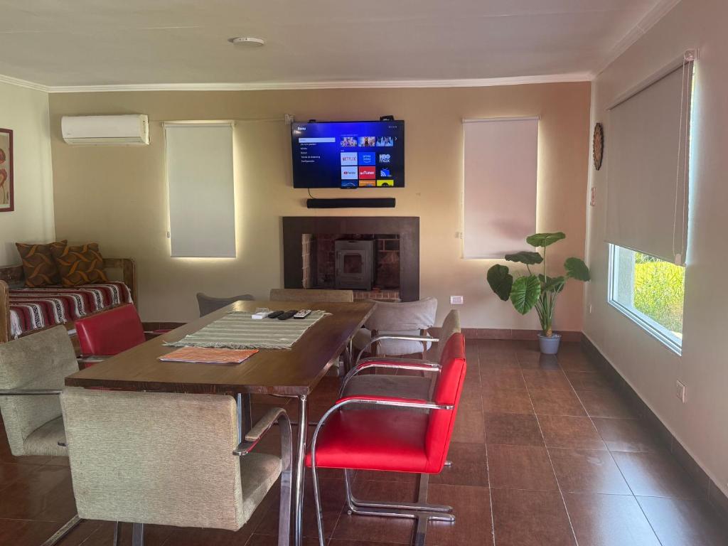 a living room with a dining room table with red chairs at paraíso la Caleta in Mar de Cobo