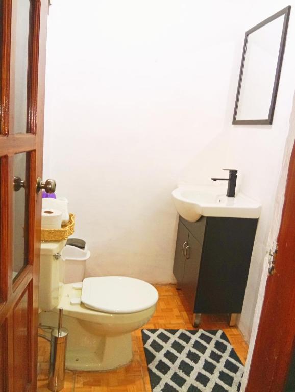 a bathroom with a toilet and a sink at Casa de descanso in Alajuela City