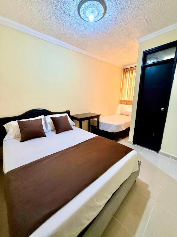a hotel room with a large bed and a table at Hotel Buenavista Valledupar in Valledupar