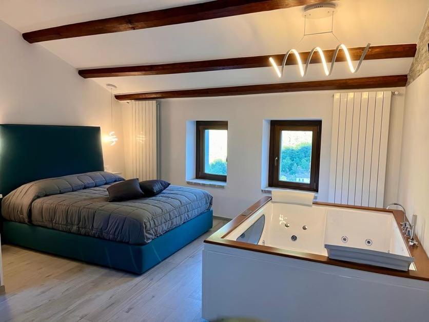 a bedroom with a bed and a tub in it at Il Cuore d'Abruzzo in Introdacqua