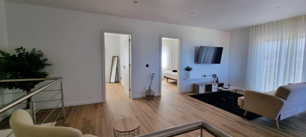 a white living room with a couch and a table at The Frenchie's House in Rabo de Peixe