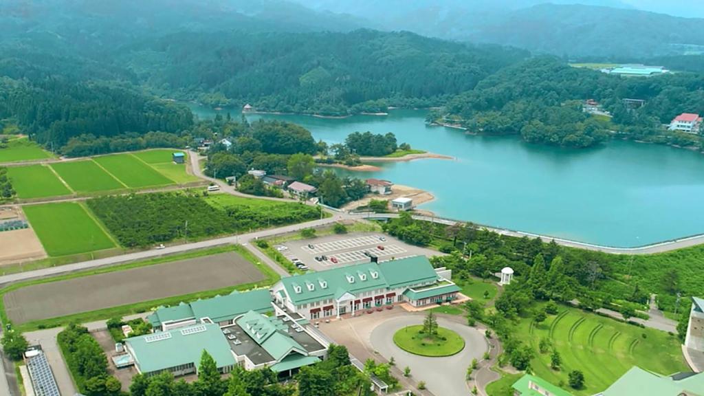 - une vue aérienne sur un lac avec un complexe dans l'établissement Satoyama Auberge & Hot Spring Wellness Spa Sakuragaike Kurgarden, à Nanto