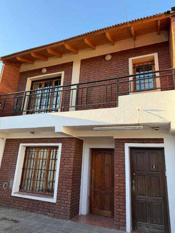 a brick building with two doors and a balcony at desertico in Neuquén