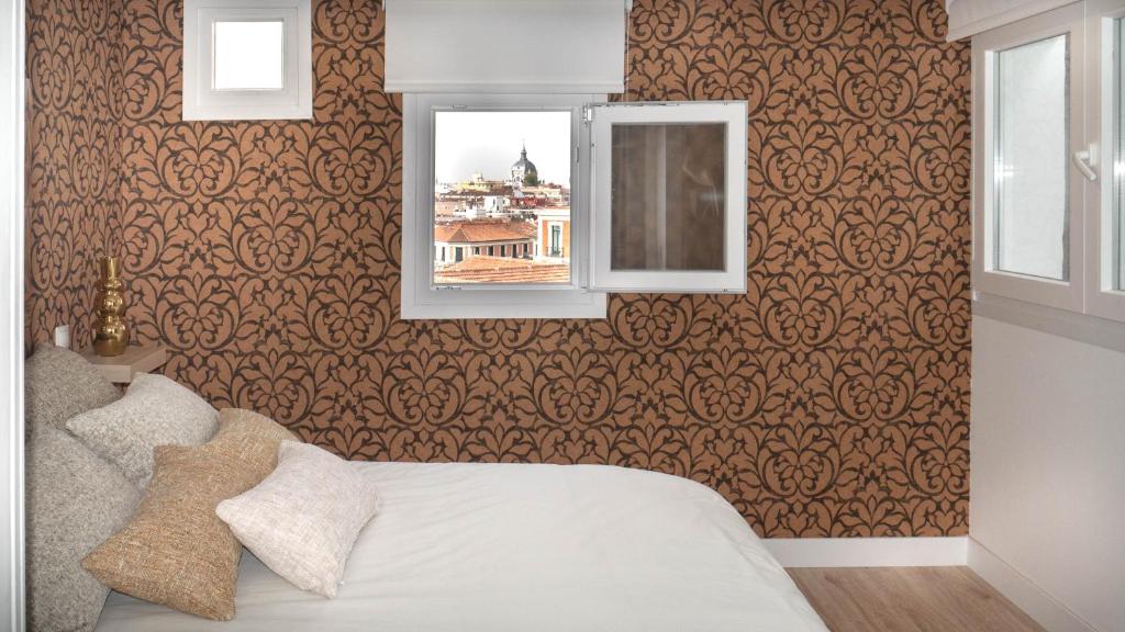 a bedroom with a bed and a mirror and a window at Apartamento Preciados in Madrid