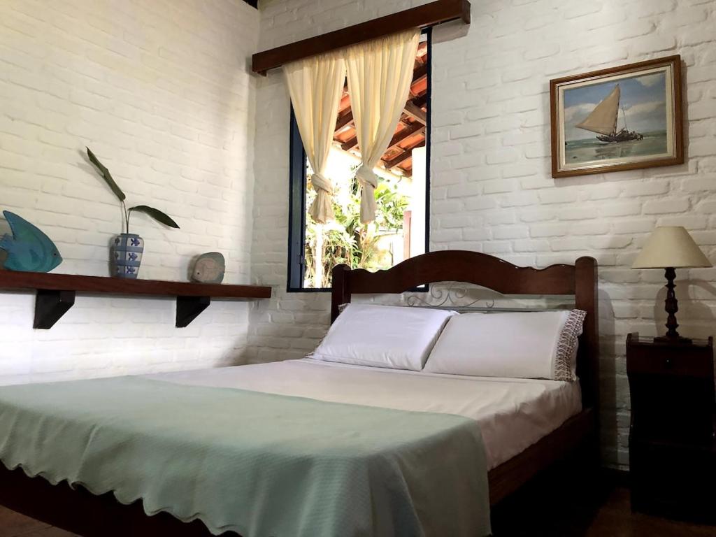 a bed in a room with a window and a bed sidx sidx sidx at Paraiso de Angra in Angra dos Reis