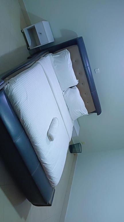 a bed with white sheets and pillows in a room at Vickie's Home in Lagos