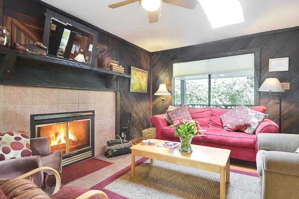 a living room with a red couch and a fireplace at The Boat House in Guerneville