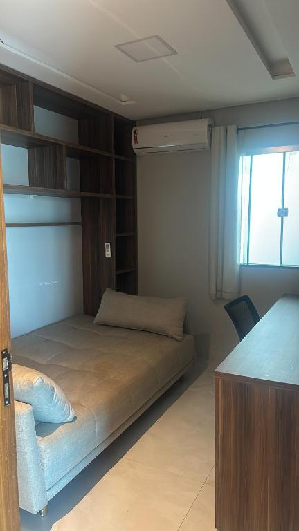 a bedroom with a bed in a room with a window at Conforto & Sofisticação in Macapá