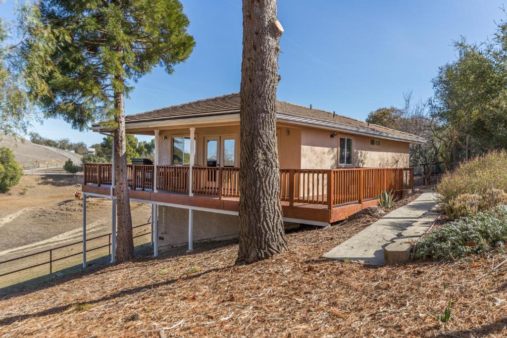 a house with a porch and a tree at Serendipity Retreat - Dogs Welcome Farm Tours and Private Yoga Sessions in Atascadero