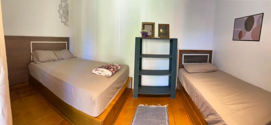 Dos camas una al lado de la otra en una habitación. en CASA DE CHICO, en Guarda do Embaú