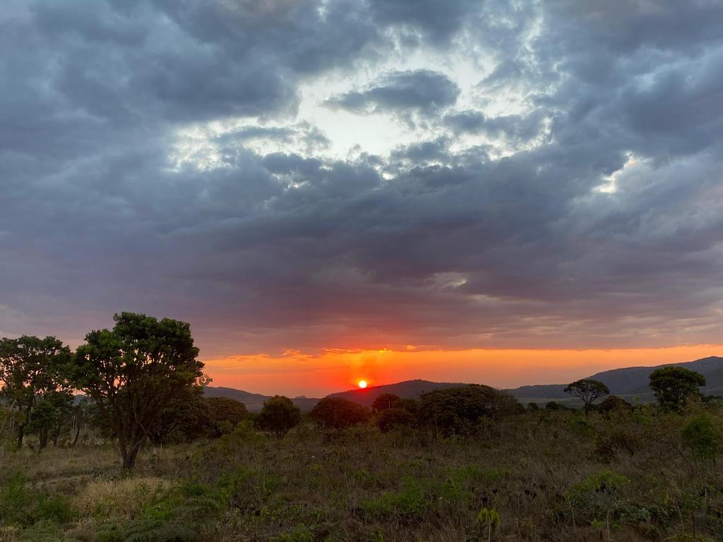 una puesta de sol en un campo con la puesta de sol en Chalé Pôr do Sol II, en Alto Paraíso de Goiás