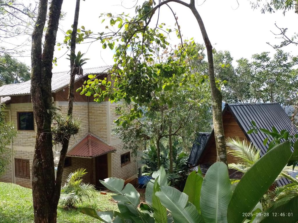 ein Haus mit Bäumen davor in der Unterkunft Morada Paraíso dos Canyons in Praia Grande