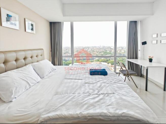 Una cama blanca grande en una habitación con ventana. en Newly Studio Nyaman U Residence 2, en Bojongrarang