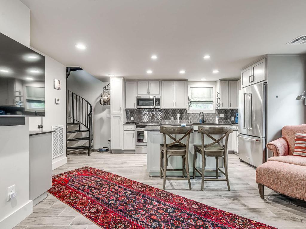 a kitchen with white cabinets and a red rug at Cozy 1-Bedroom Retreat in Tulsa in Tulsa