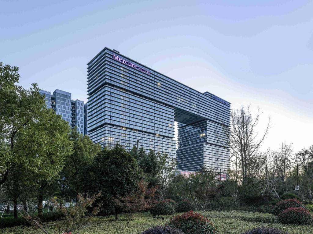 a tall building with a sign on the side of it at Mercure Hangzhou Xixi Wetland in Yuhang