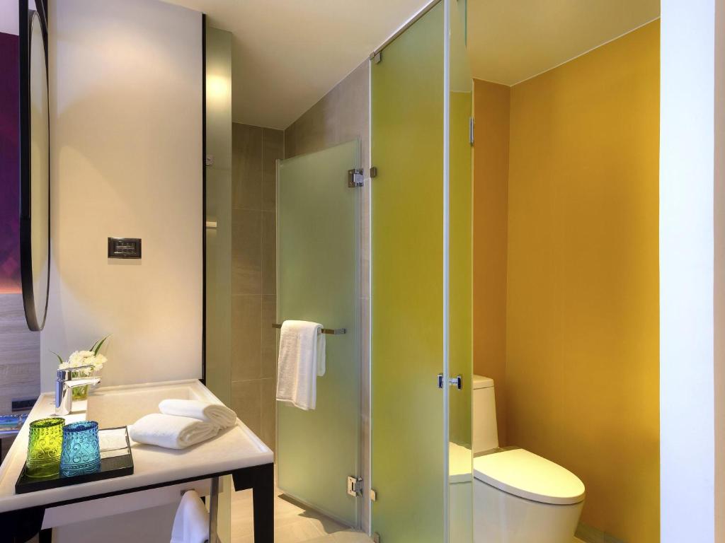 A compact bathroom with a glass-enclosed shower and toilet.