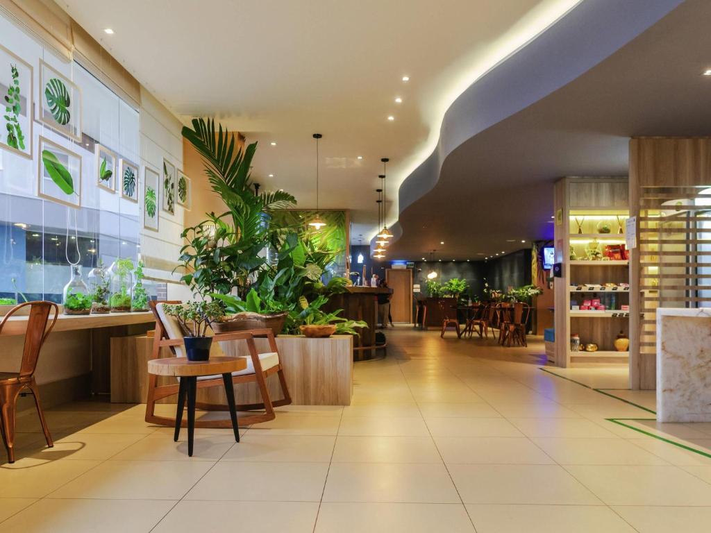 a lobby of a store with plants on the walls at ibis Styles Curitiba Aeroporto in São José dos Pinhais
