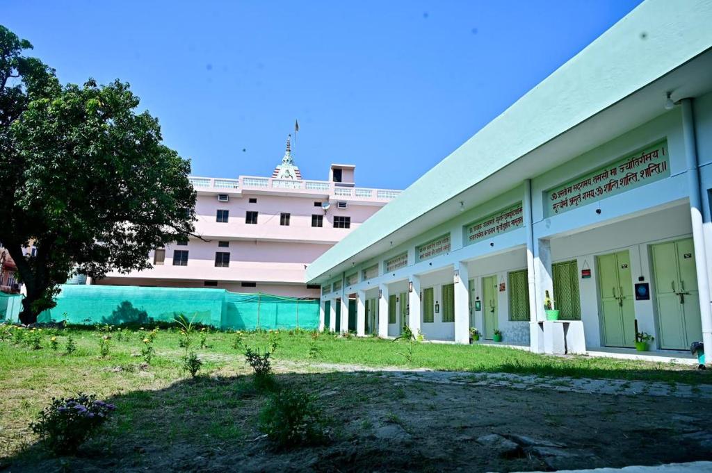 a large white building with a large boat in the background at Prakriti wellness stay in Haridwār