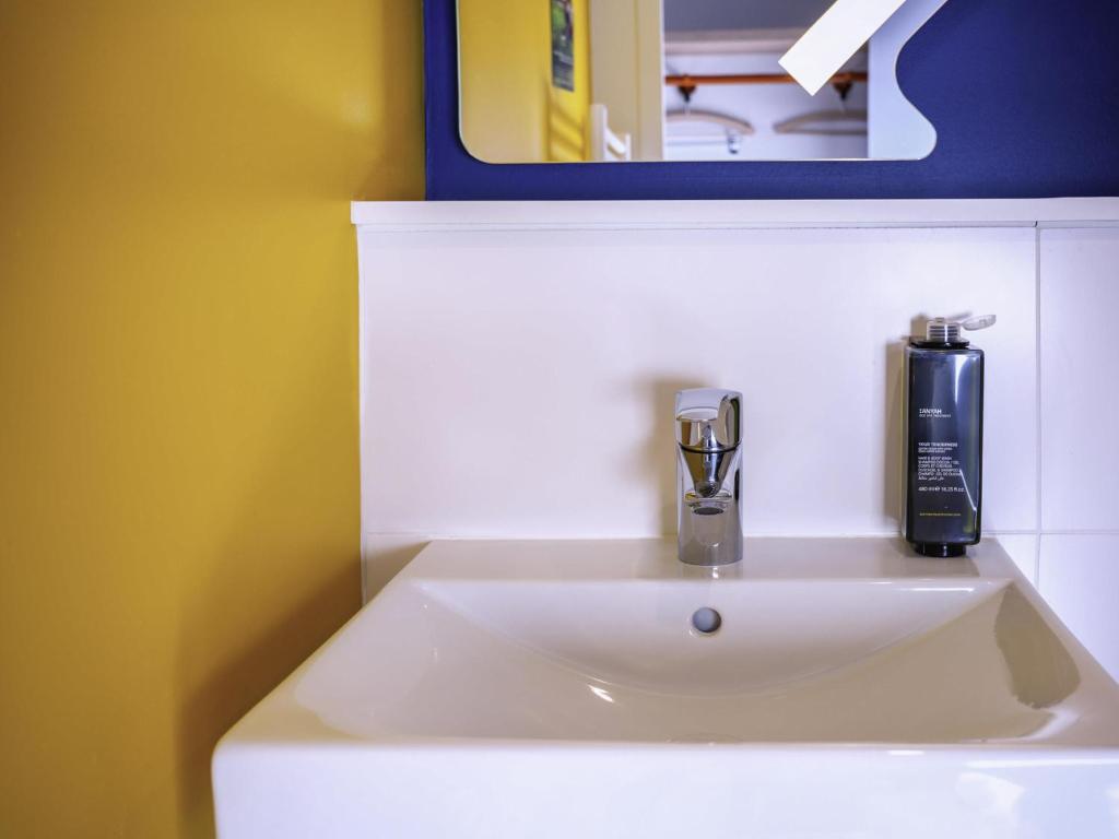 lavabo con dispensador de jabón en ibis budget Reims Parc Des Expositions, en Reims