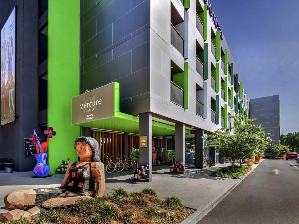 a statue of a woman sitting in front of a building at Mercure Bendigo Schaller in Bendigo