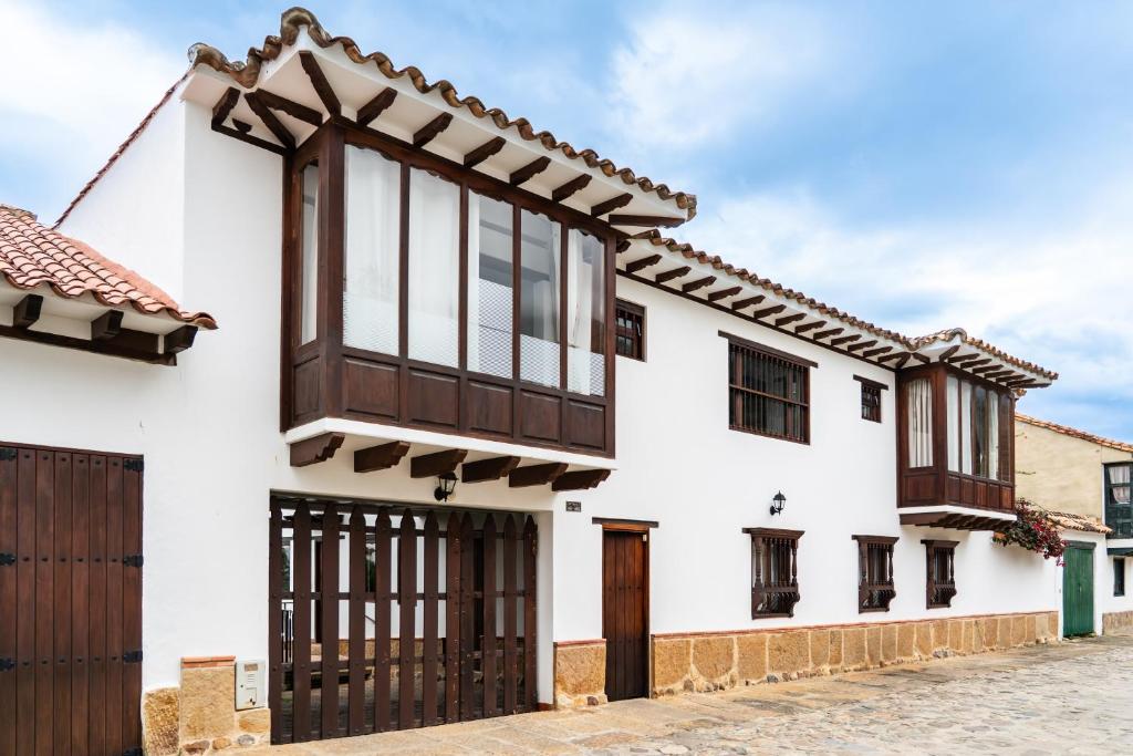 a white house with wooden doors and windows at La Heredad Villa de Leyva in Villa de Leyva