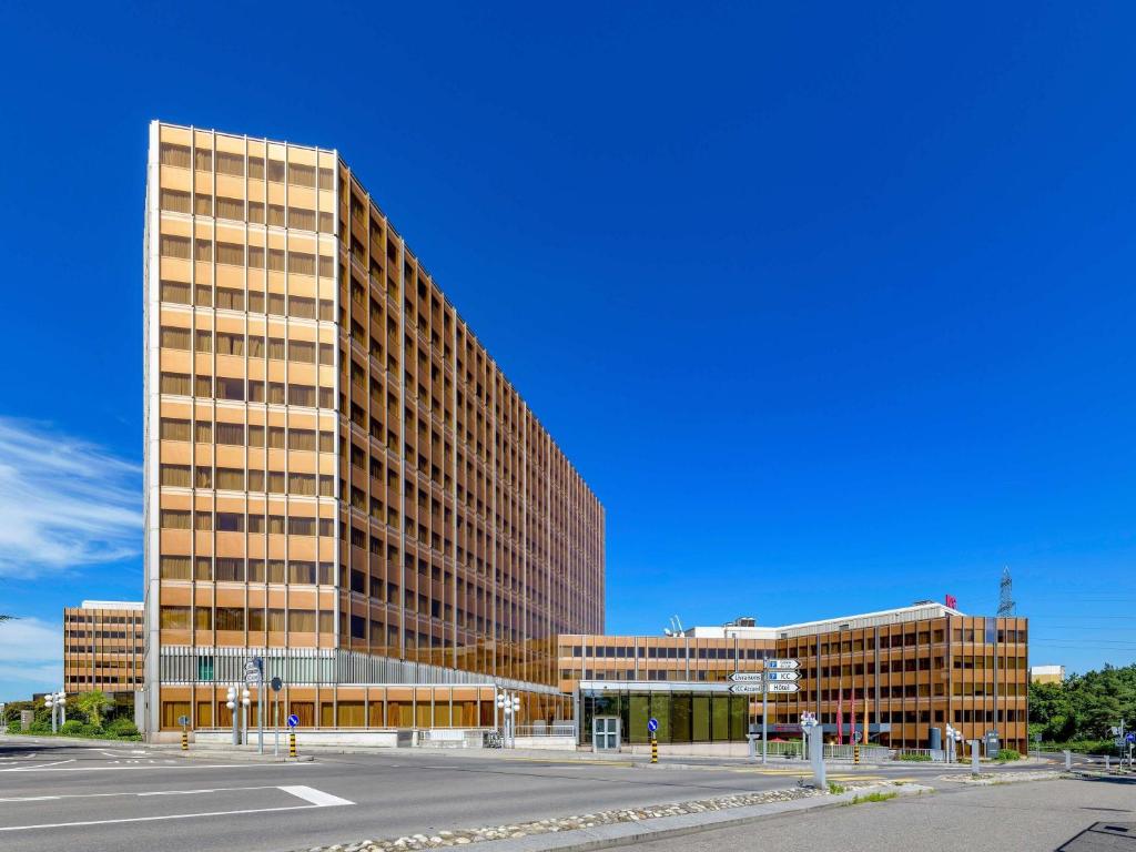 a tall building with a street in front of it at Mövenpick Hotel Geneva in Geneva