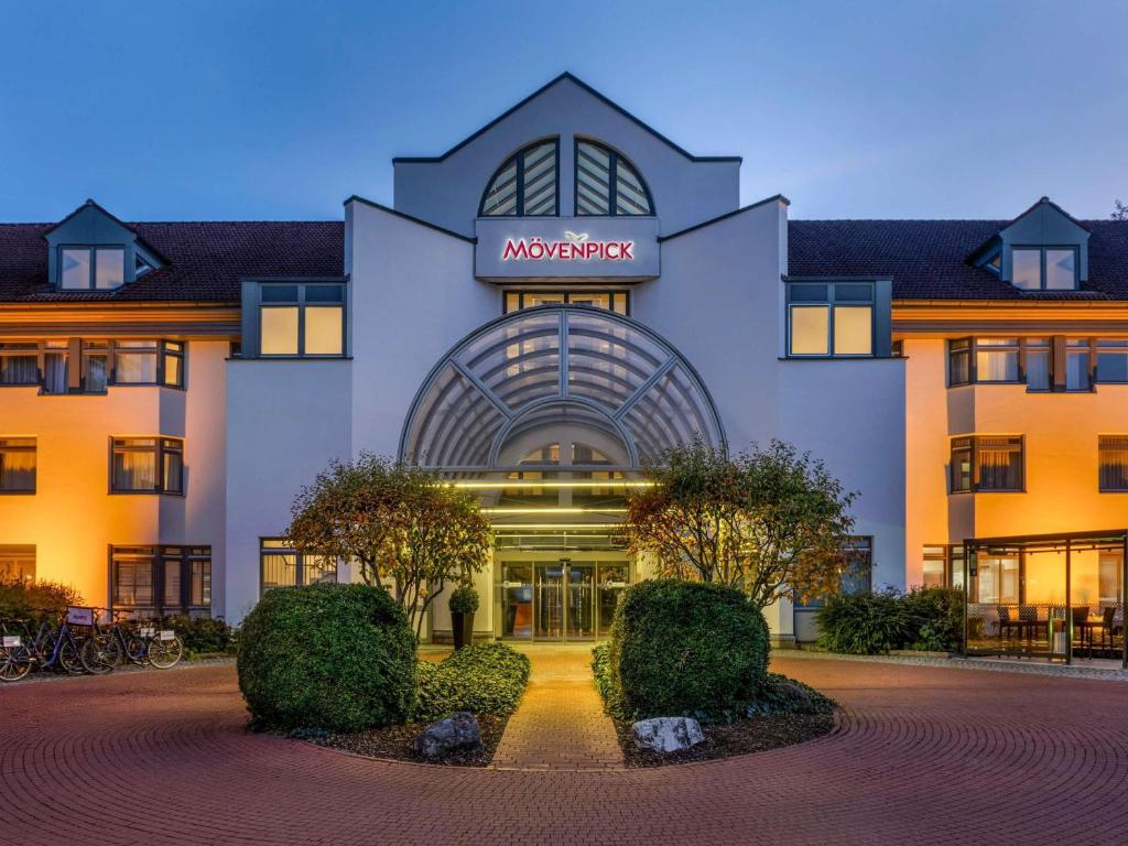 a hotel building with a sign on the front of it at Mövenpick Hotel München-Airport in Hallbergmoos