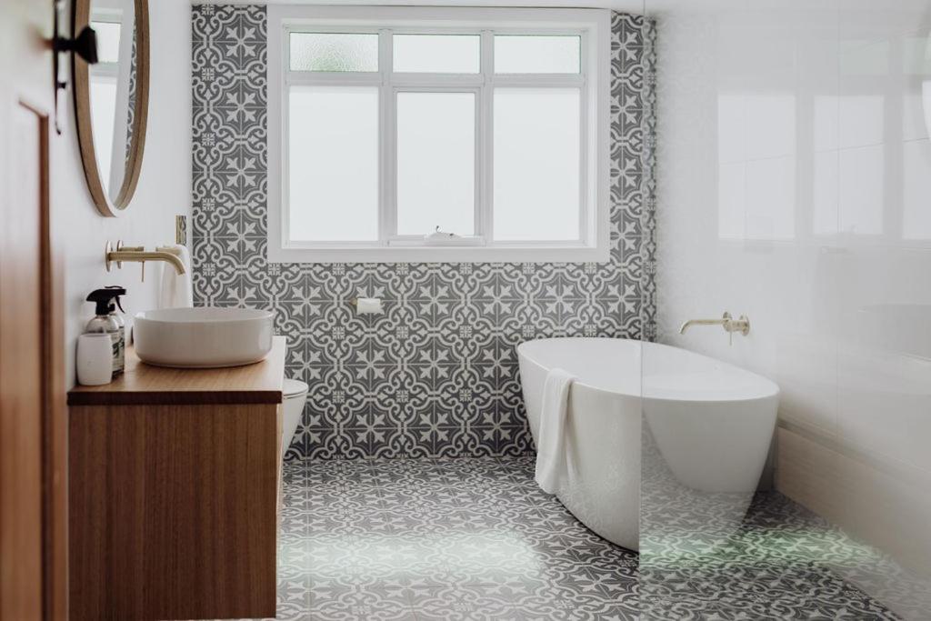 een badkamer met een bad, een toilet en een wastafel bij Bicheno Beach House in Bicheno