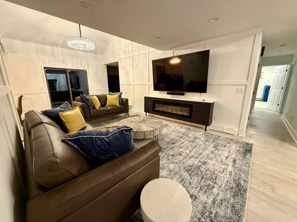 Highland LakesTop Luxe Oasis -Ski, Hike, Firepit, Spa, Golf的客厅里有一张沙发和一台电视