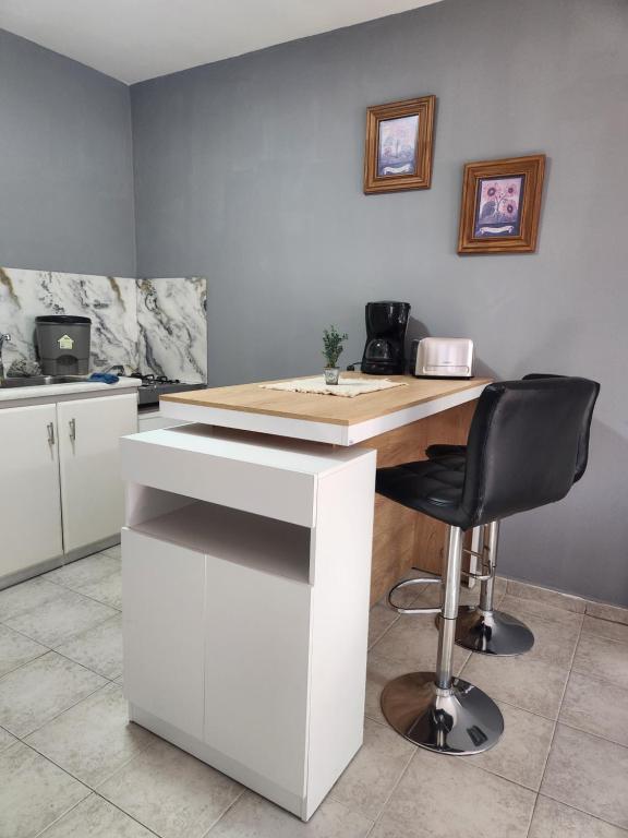 Una cocina con un escritorio blanco y una silla negra. en Namaste, en Río Gallegos