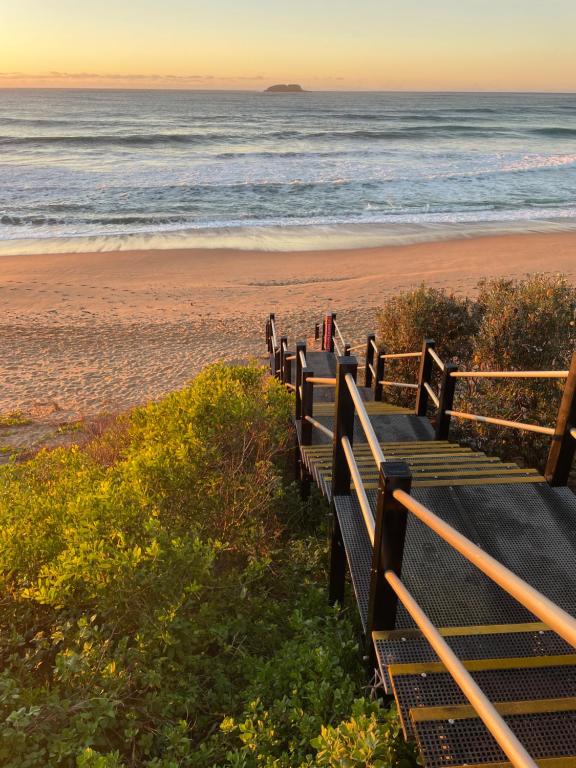 a row of benches on the beach at sunset at Stones Throw at Sapphire in Coffs Harbour