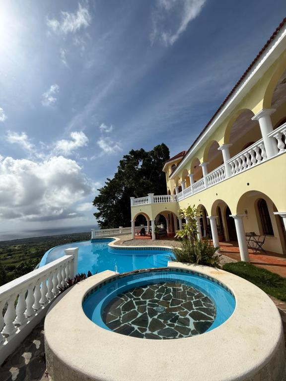 an exterior view of a large house with a swimming pool at El Castillo Tropical Desconéctate de la civilización in Nagua