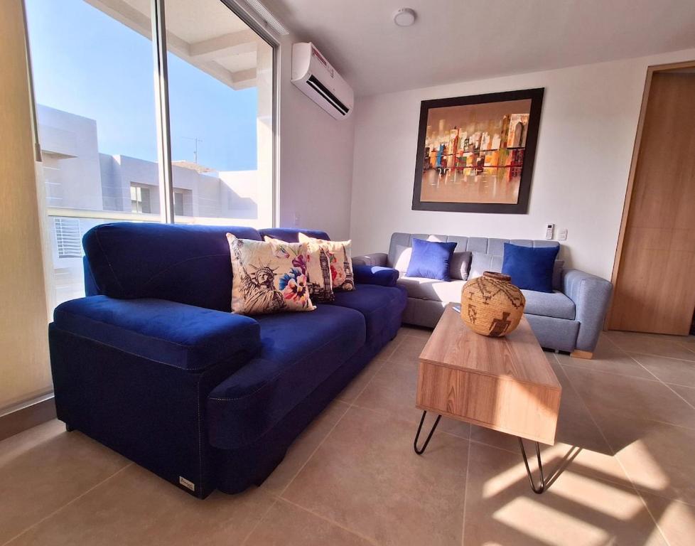 a living room with a blue couch and a table at Cartagena zona norte playa uso exclusivo in Cartagena de Indias
