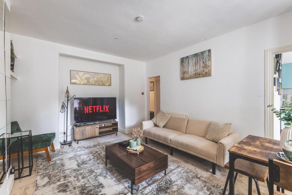 a living room with a couch and a tv at Sleeps 5! Parking, WiFi & Parking, 4 Mins To Station, NEWLY REFURBISHED!! in London