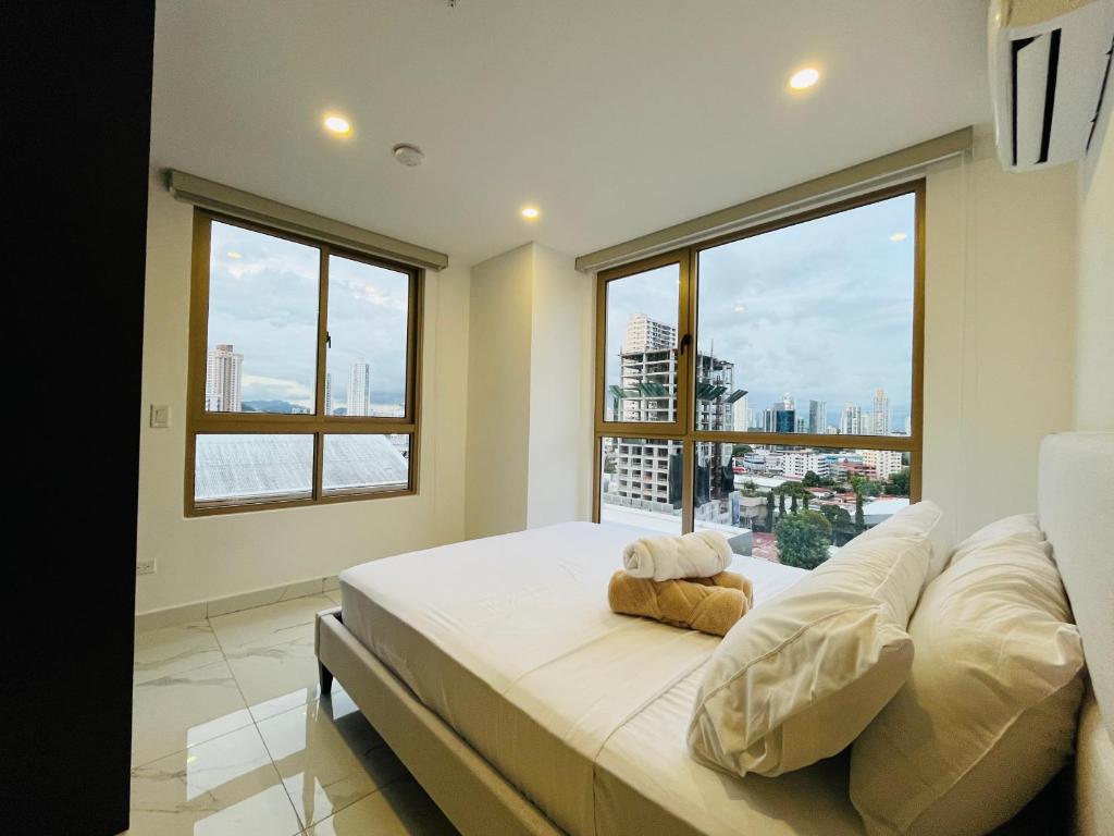 a bedroom with a large bed with a large window at Moderno apartamento en el centro de Obarrio in Panama City