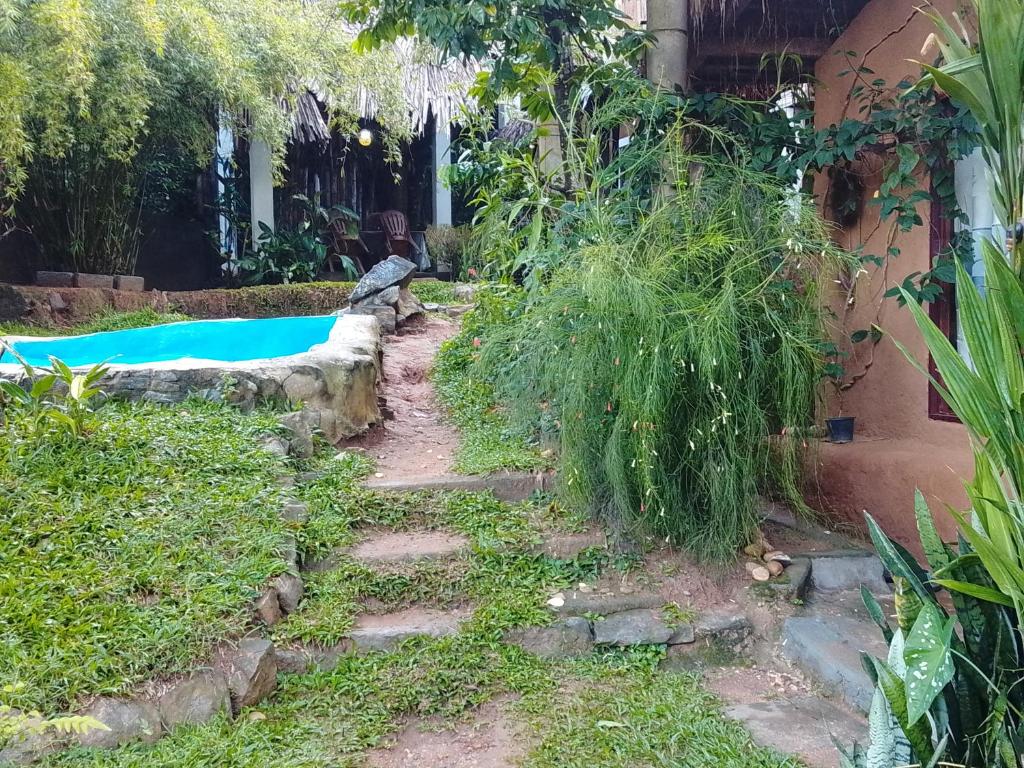 a garden with stairs next to a swimming pool at Ancient Grand Villa in Pinnawala