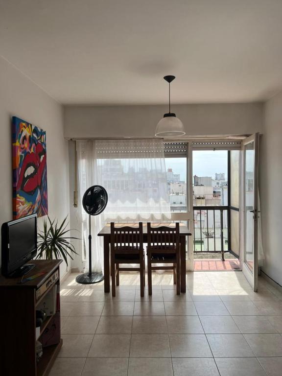 a living room with a table and a large window at Luminoso departamento a tres cuadras del mar in Mar del Plata