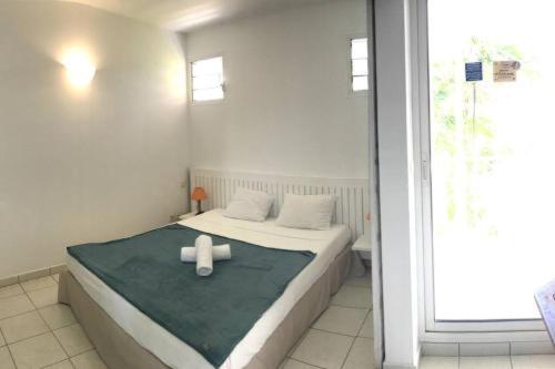 a bedroom with a bed with two white towels on it at La baie du Pitaya in La Trinité