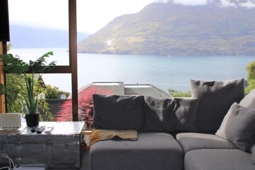 a living room with a couch and a view of a lake at The Cameron Bothy in Queenstown