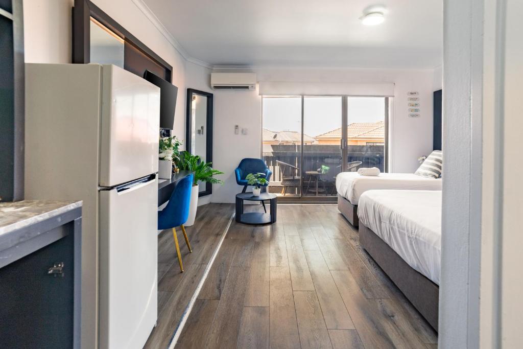 Il comprend une chambre avec un lit et une cuisine équipée d'un réfrigérateur. dans l'établissement Bankstown Motel 10, à Bankstown