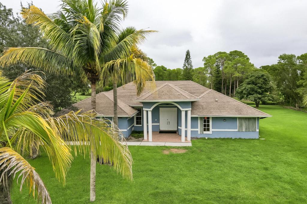 a house with a palm tree in the yard at Large 5BR Home – Pool Table Yard Beaches in Delta