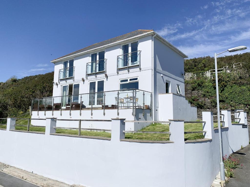 una casa blanca detrás de una valla blanca en Looe Island View, en Torpoint
