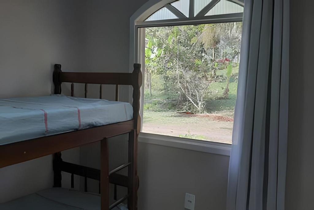een slaapkamer met een stapelbed en een raam bij Sonho do Mar in Antonina