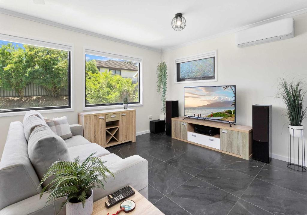 a living room with a couch and a flat screen tv at The Nook - Lake Illawarra in Lake Illawarra